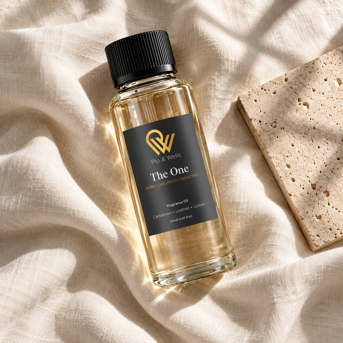 Fles Pip & Wells The One geurolie van 120 ml op licht linnen naast een stenen tegel met reliëf