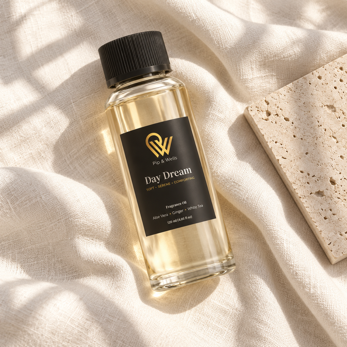Fles Pip & Wells Day Dream geurolie van 120 ml op licht linnen naast een stenen tegel met reliëf